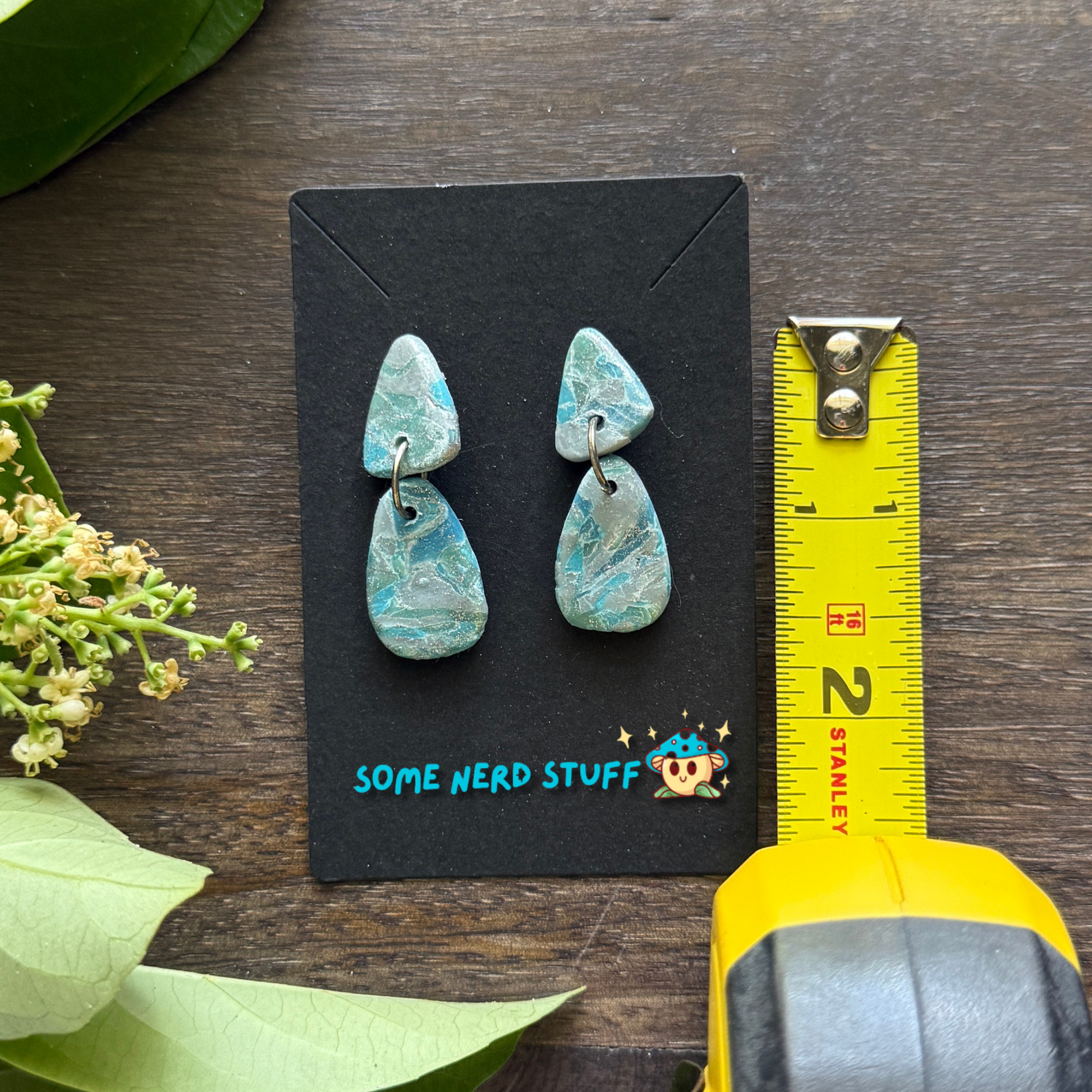 Close up of faux polymer clay faux stone earrings from SomeNerdStuff Store with a measuring stick showing 1.75 inches long