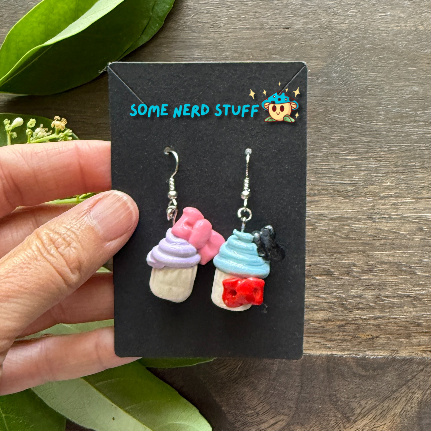Donald and Daisy Duck Cupcake Earrings made with Polymer Clay held in hand to show size by SomeNerdStuff