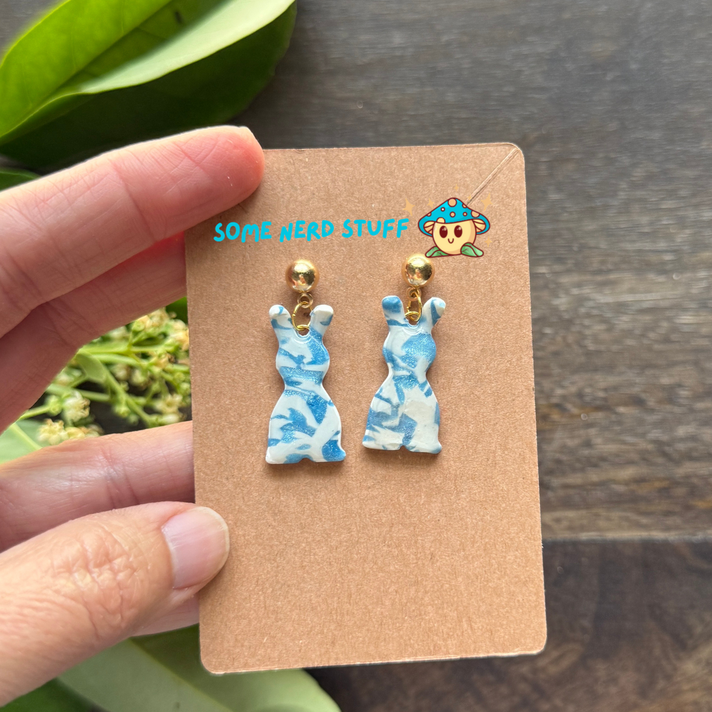 Polymer Clay Earring inspired by white and blue granit stone shown in hand to show size of earrings.