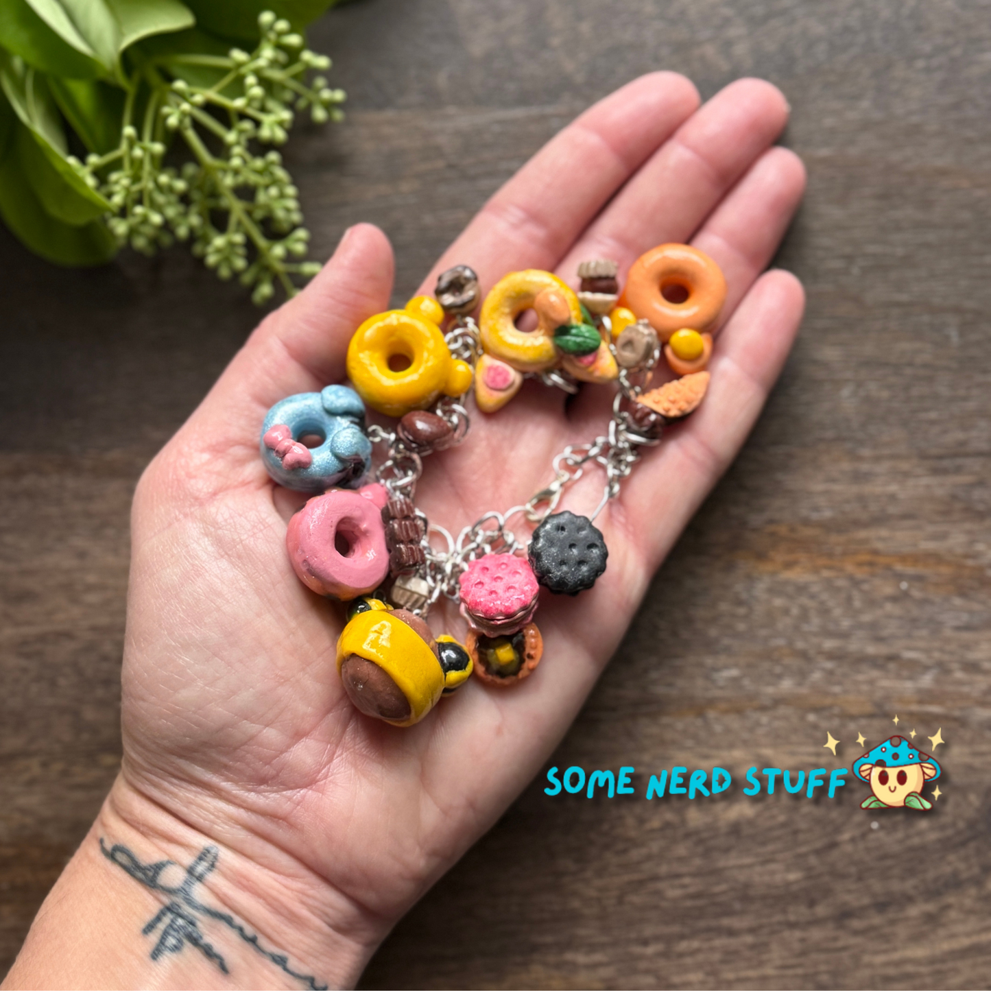 Disney Winnie the Pooh polymer Clay inspired bracelet with mini desserts and character charms shown in hand for size made by SomeNerdStuff