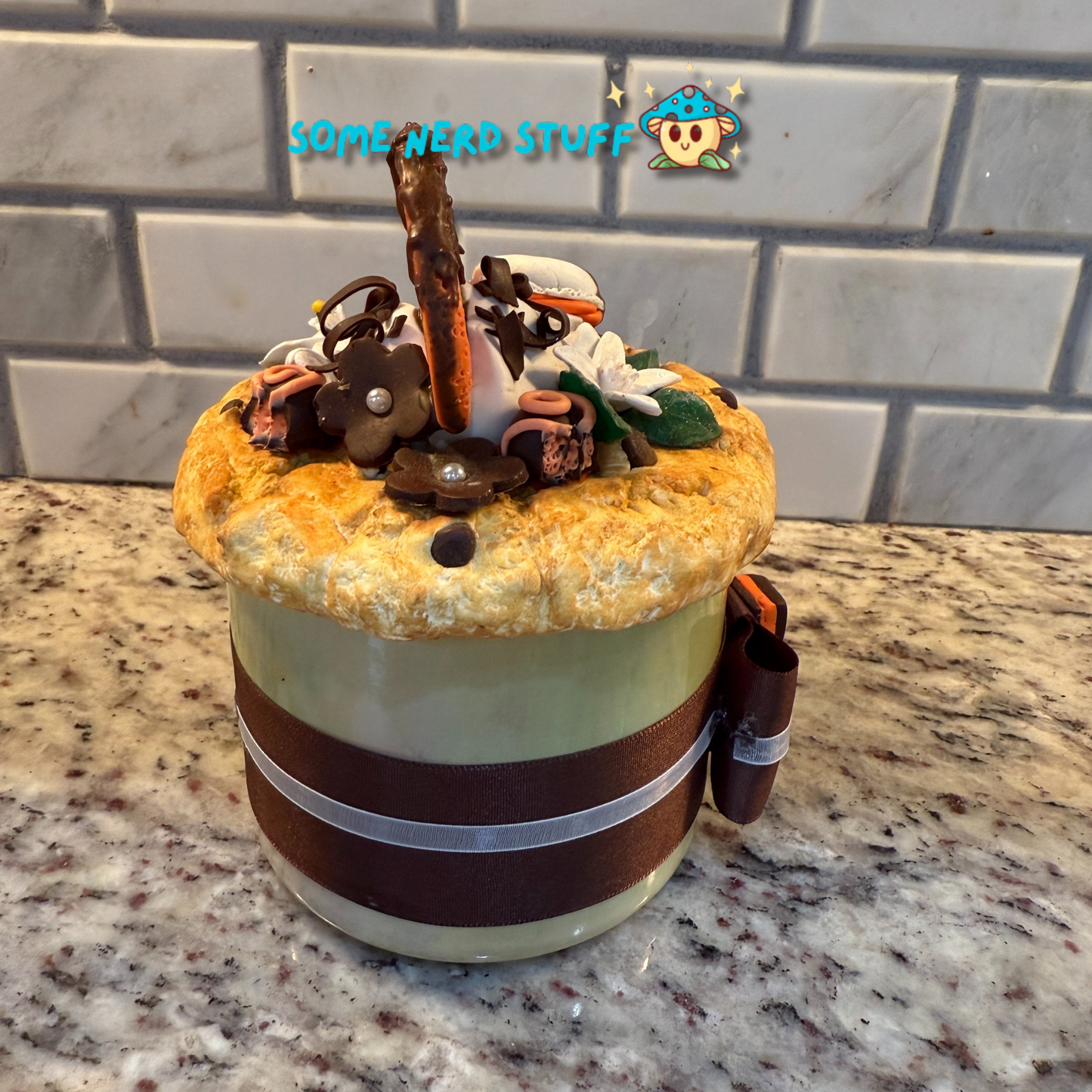 Polymer Clay Stash Jar Topped with faux Orange dipped chocolate, vanilla macaron, jasmine flower, and candies side view