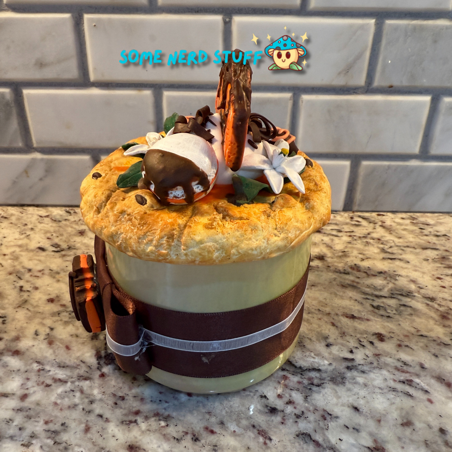Polymer Clay Stash Jar Topped with faux Orange dipped chocolate, vanilla macaron, jasmine flower, and candies.