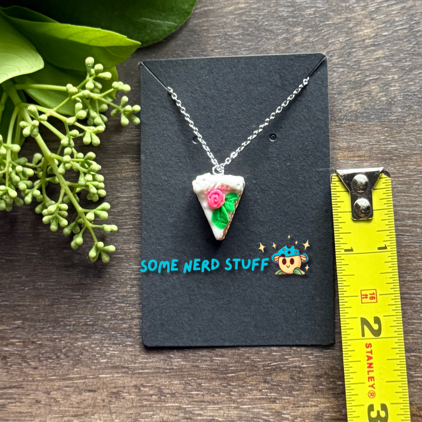 Pretty in Pink Polymer Clay necklace top view with pink rose and green petals shown with measuring tape for size