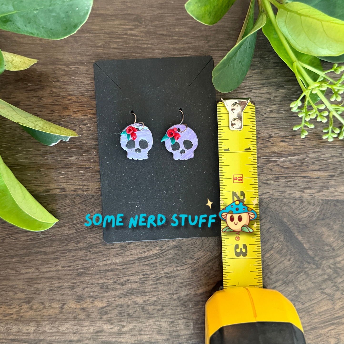 Purple Polymer Clay skulls decorated with red roses shown with measuring tape made by SomeNerdStuff