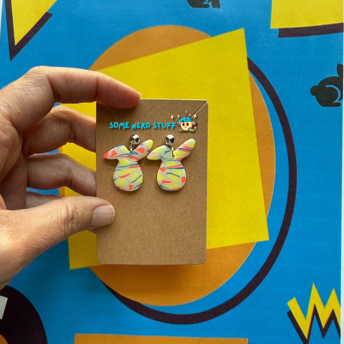 Bunny Head Polymer Clay Earrings inspired by Saved by the Bell 90s show multicolor held by hand to show size made by SomenerdStuff