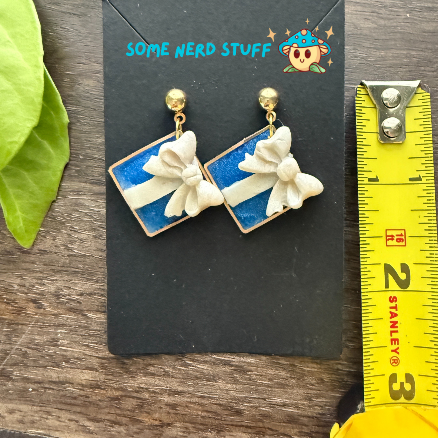 Tiffany's jewlery inspired polymer clay bow earrings, shown with measuring tape for size.