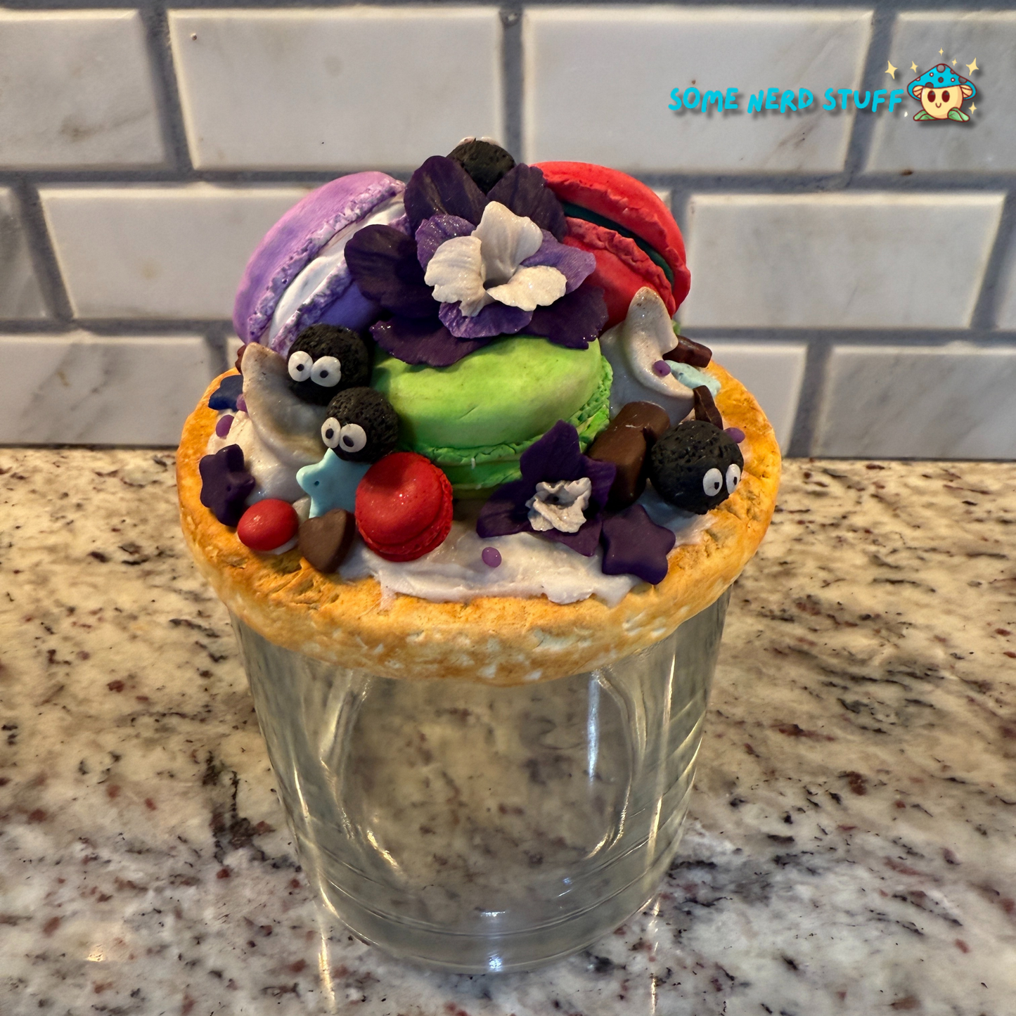 Soot Sprite Stash Jar topped with polymer clay macarooms, Soot Sprites, chocolate pieces, orchids.