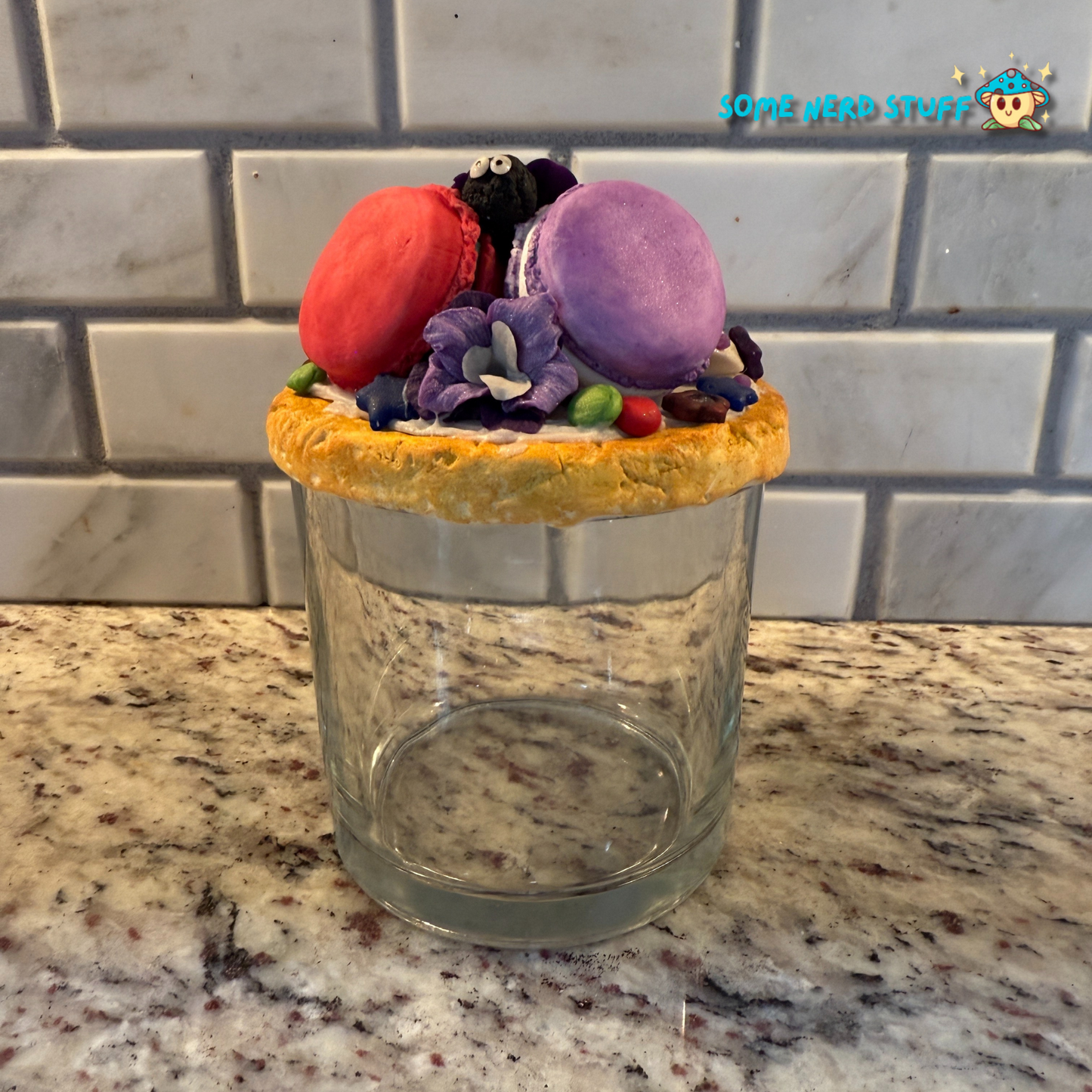 Soot Sprite Stash Jar topped with polymer clay macarooms, Soot Sprites, chocolate pieces, orchids.