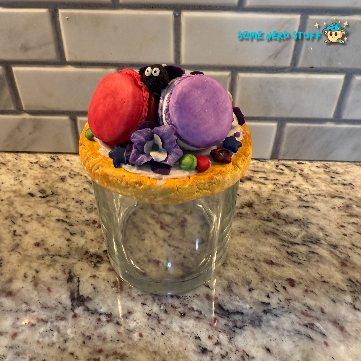 Soot Sprite Stash Jar topped with polymer clay macarooms, Soot Sprites, chocolate pieces, orchids back of jar