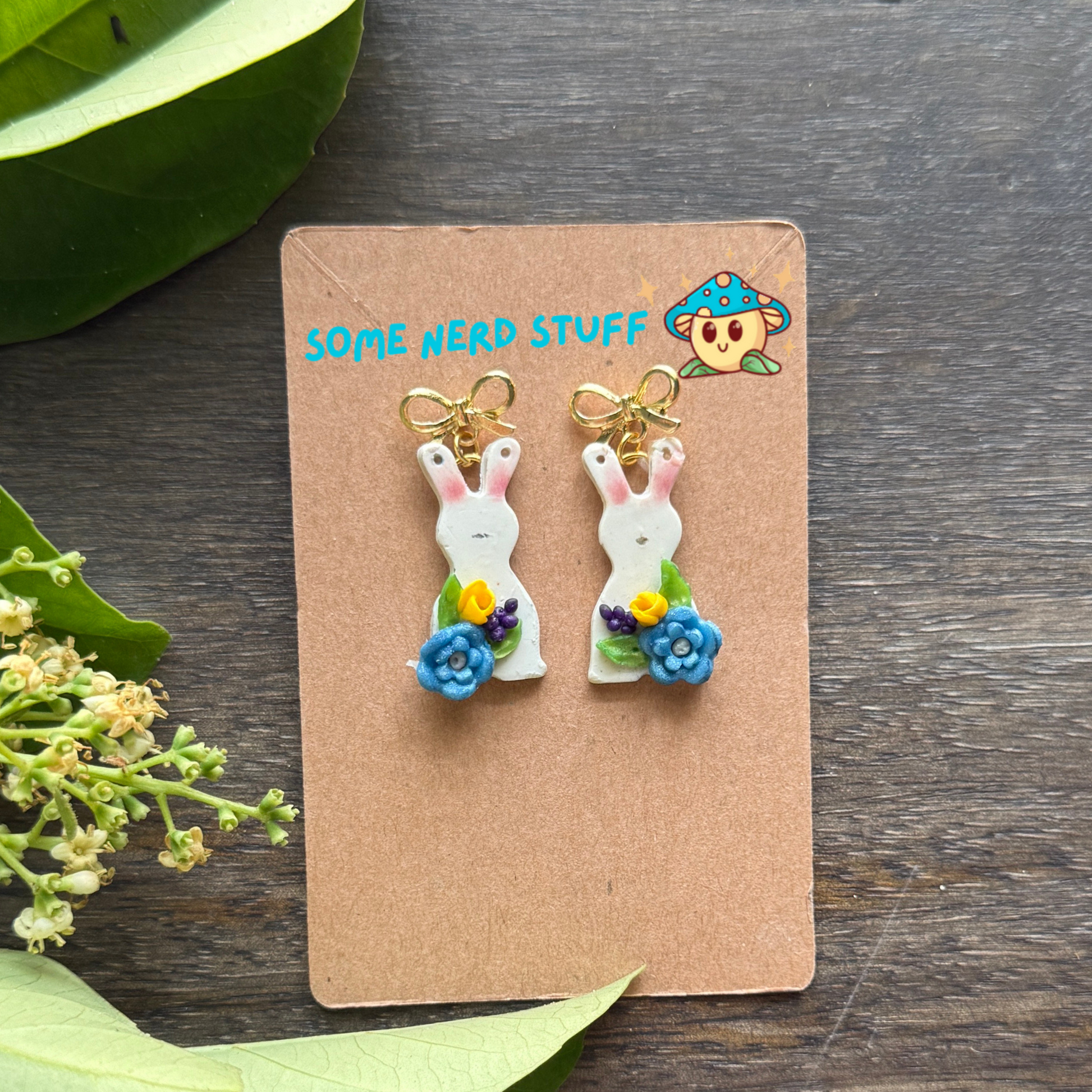 Bunny Polymer clay earrings with petite blue and yellow flwoers topped with a bow post.