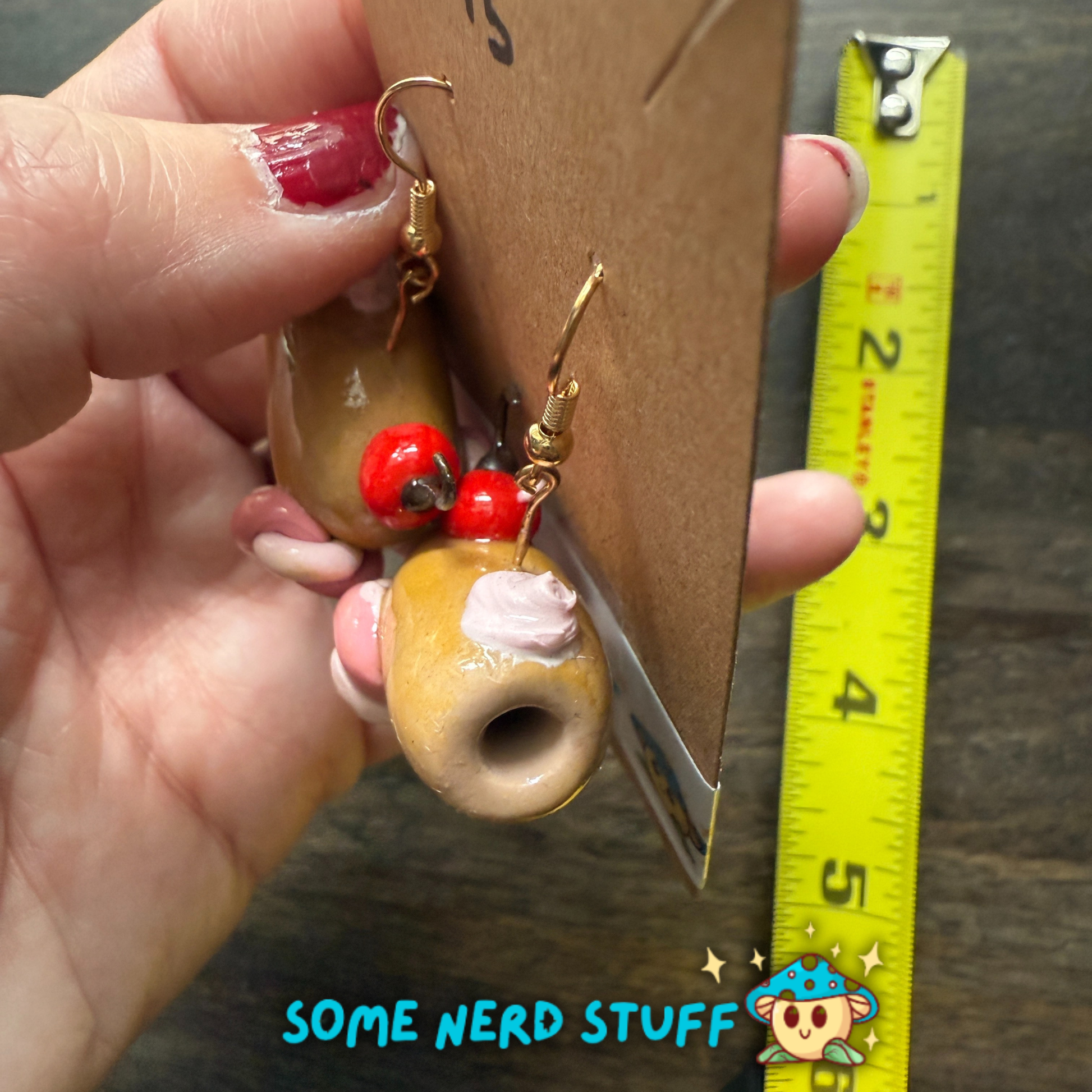 Candy cannon with faux pink whipoped cherry topped polymer clay earrings sold on SomeNerdStuff with measuring tape