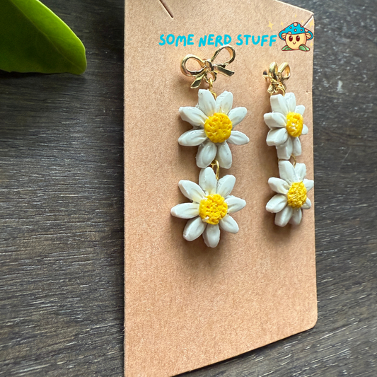 Flower-shaped earrings on a 'SOME NERD STUFF' branded card.