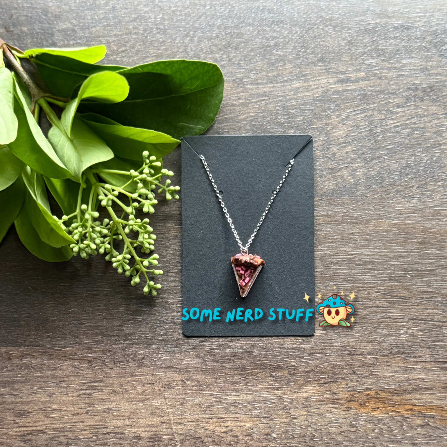 Cholcoale Ganache Cake Charm made out of polymer clay and necklace showing cake layers vanilla and strawberry made by SomeNerdStuff
