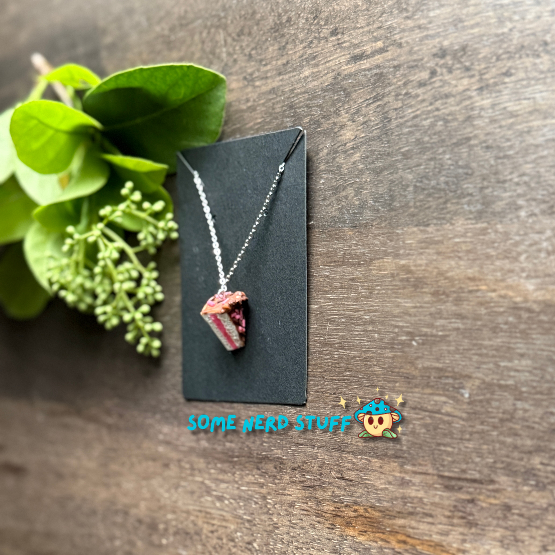 Cholcoale Ganache Cake Charm made out of polymer clay and necklace showing cake layers vanilla and strawberry made by SomeNerdStuff