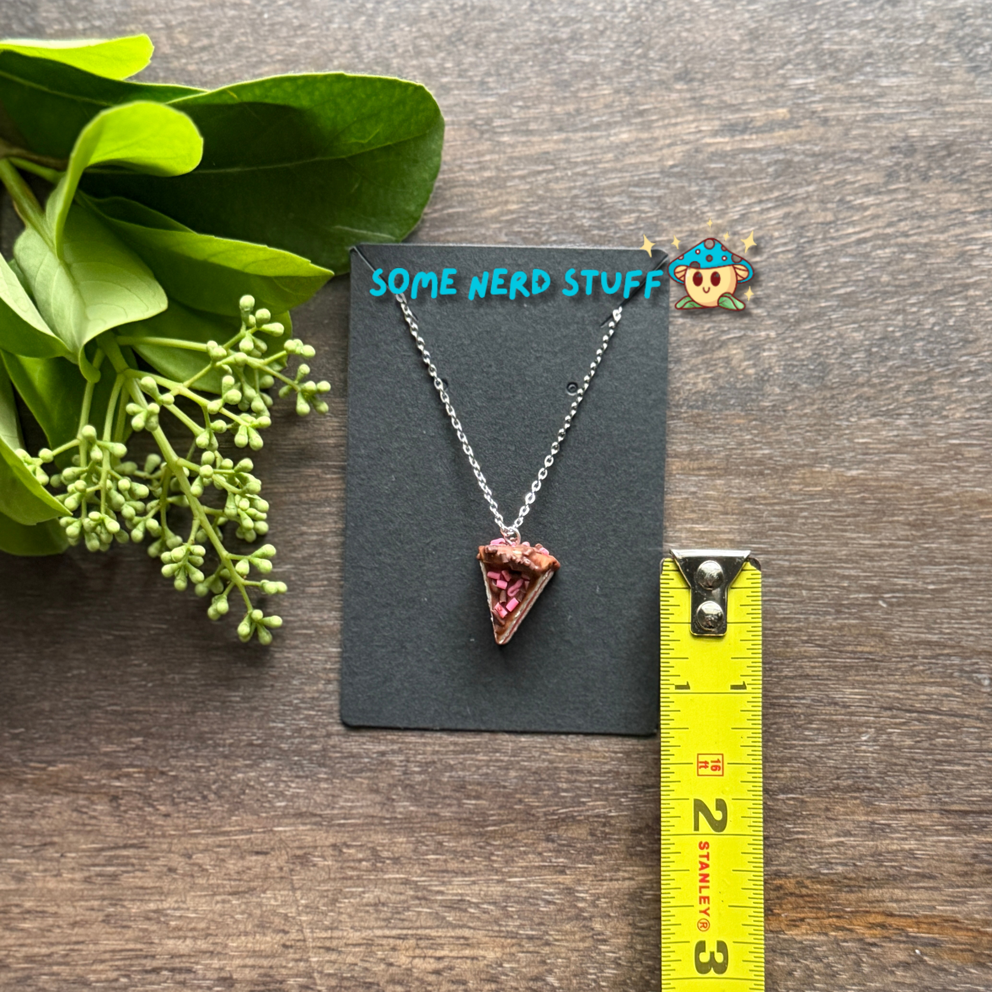Cholcoale Ganache Cake Charm made out of polymer clay and necklace showing cake layers vanilla and strawberry made by SomeNerdStuff
