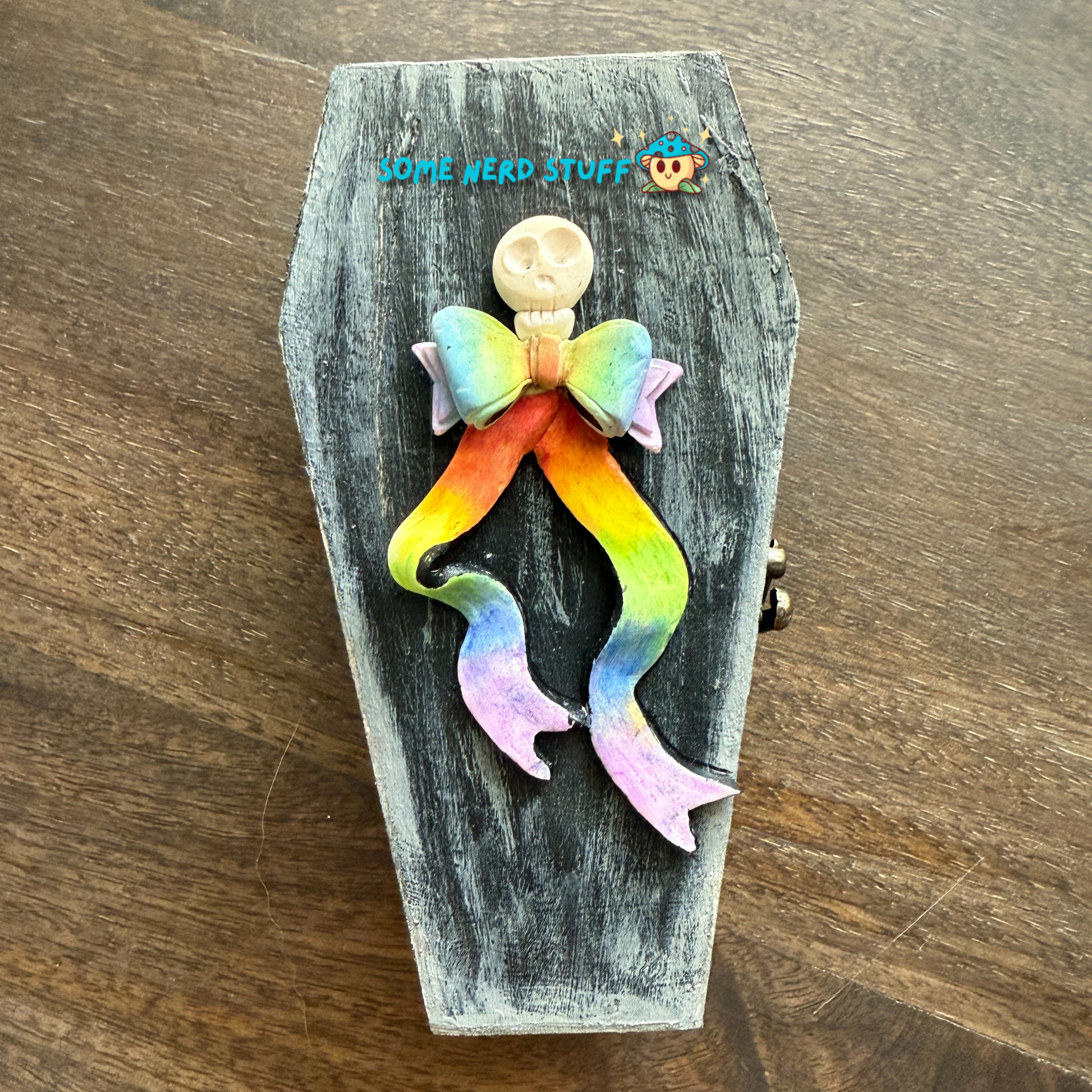 Wooden craft coffin decorated with rainbow polymer clay topped clay skull