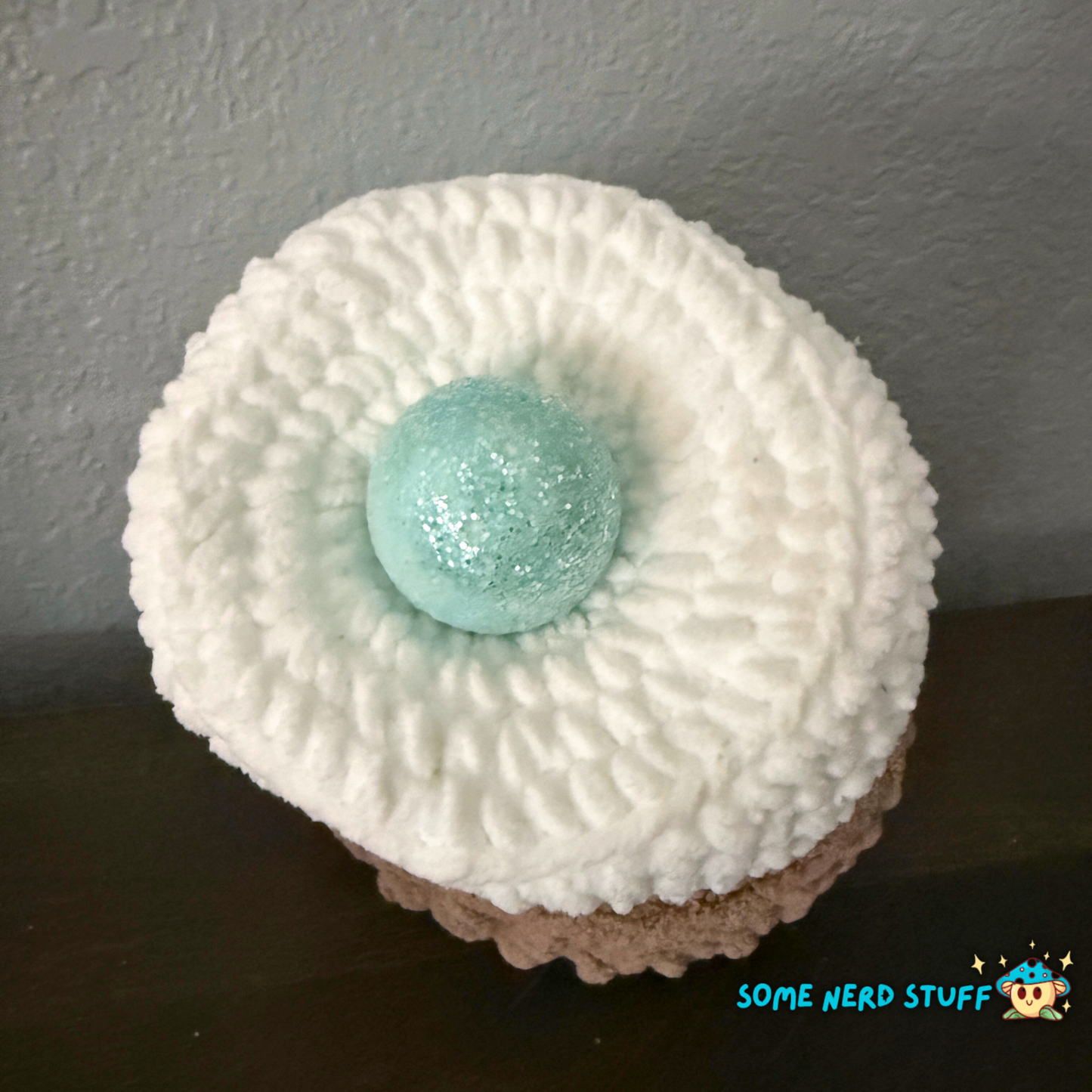 Crocheted chicken DIxie with baby cluck chick and holds a fun glitter egg all sitting on a ultra soft crocheted nest sold by SomeNerdStuff