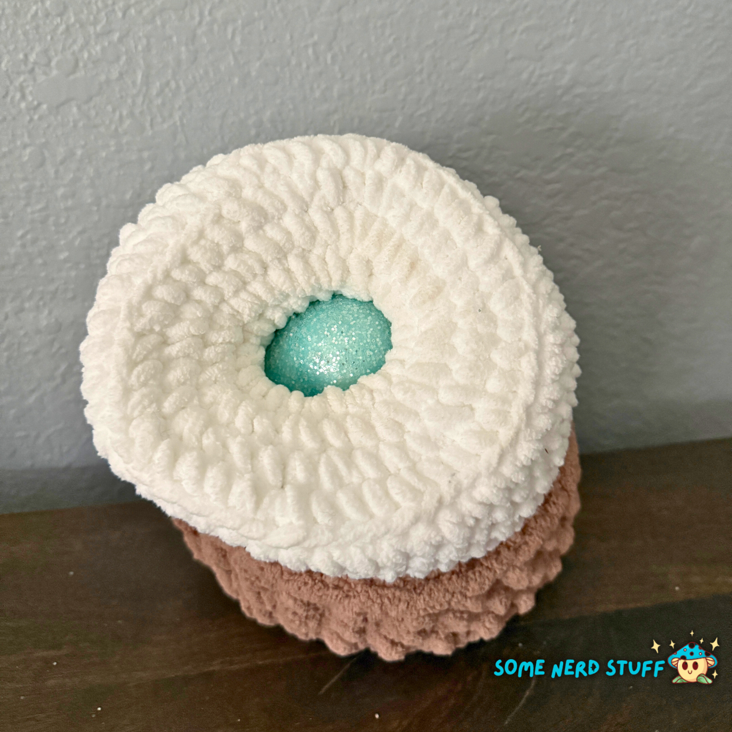 Crocheted chicken DIxie with baby chick and holds a fun glitter egg all sitting on a ultra soft crocheted nest sold by SomeNerdStuff