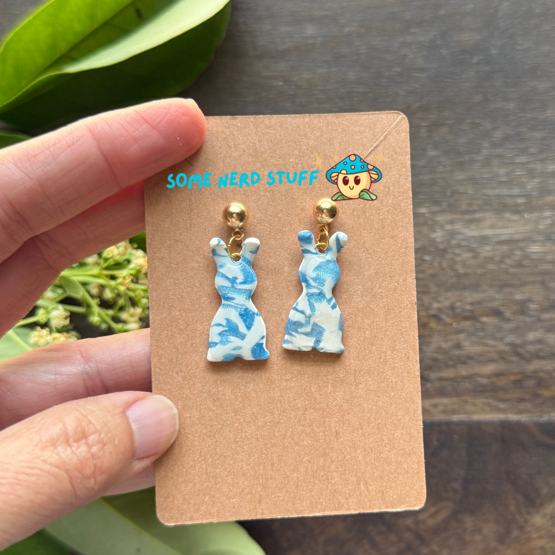 Polymer Clay Earring inspired by white and blue granit stone shown in hand to show size of earrings.