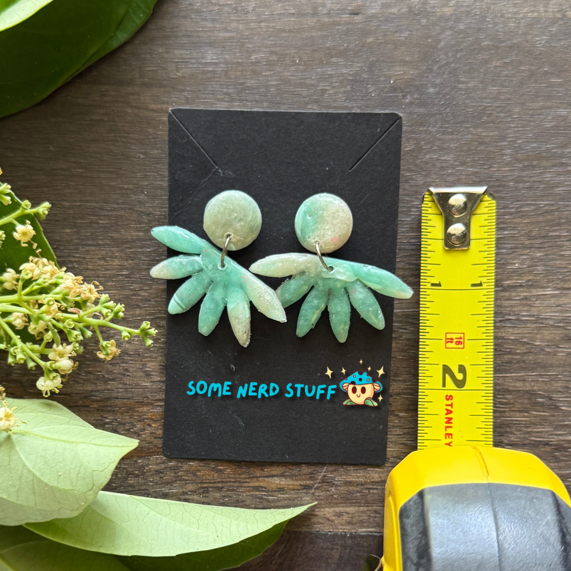 Faux polymer clay earrings with circle and horizon stone pictured with measuring tape to show height