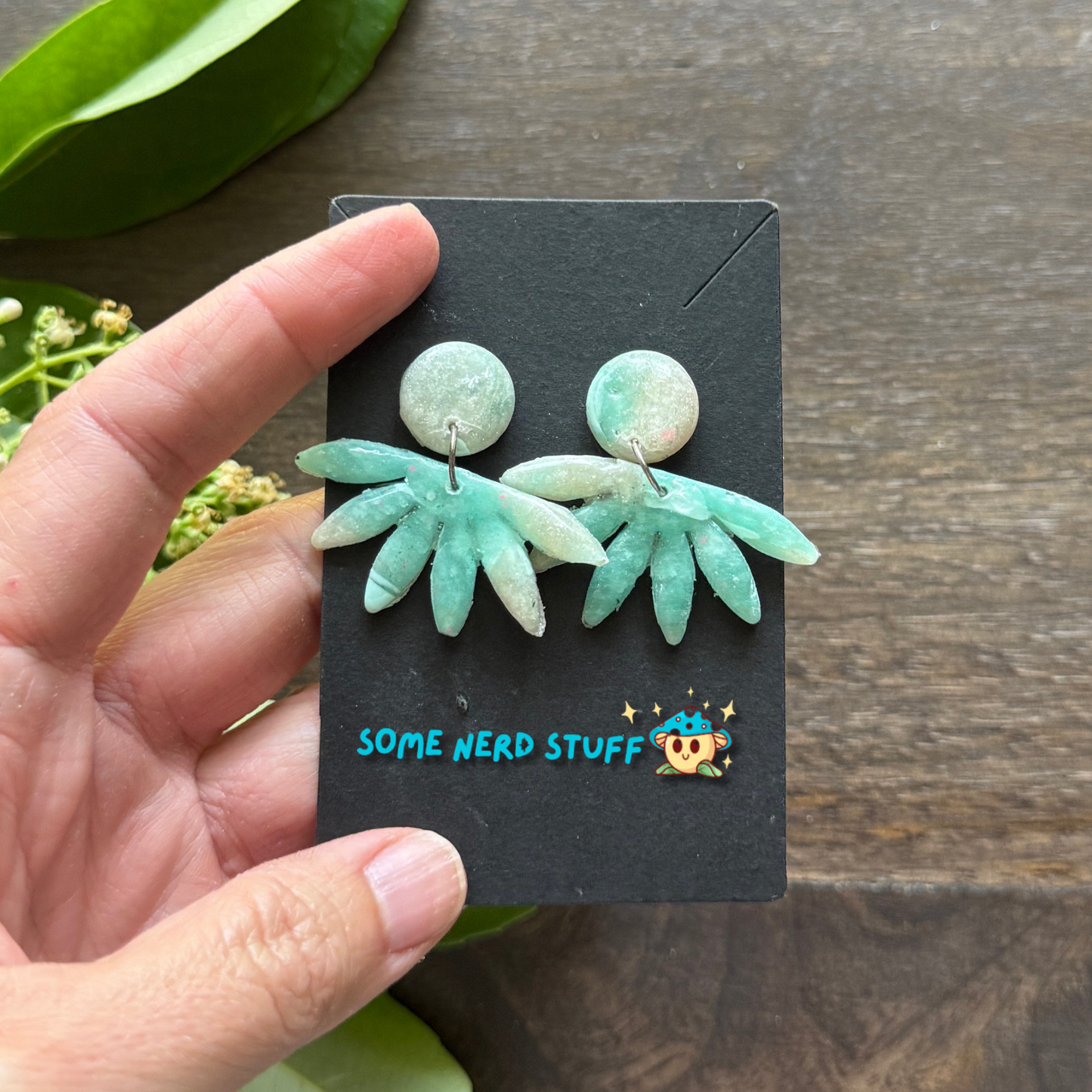 Faux polymer clay earrings with circle and horizon stone being held close up by hand showing arring size