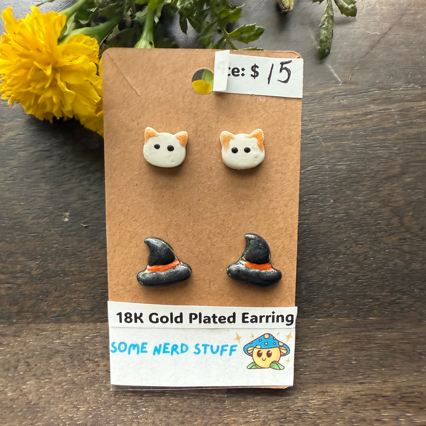 Halloween Cat and Witch hat studs that are 18k plated sold by SomeNerdStuff