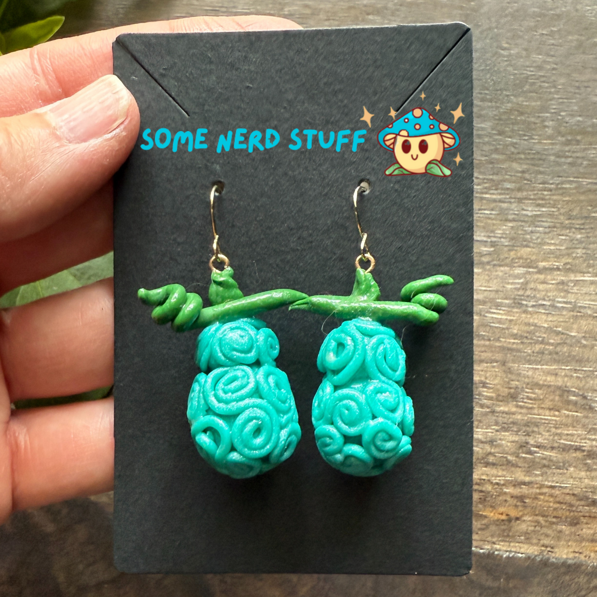 Omo Omo No Mi - Devil Fruit One Piece Earrings show in hand for size anime jewlery