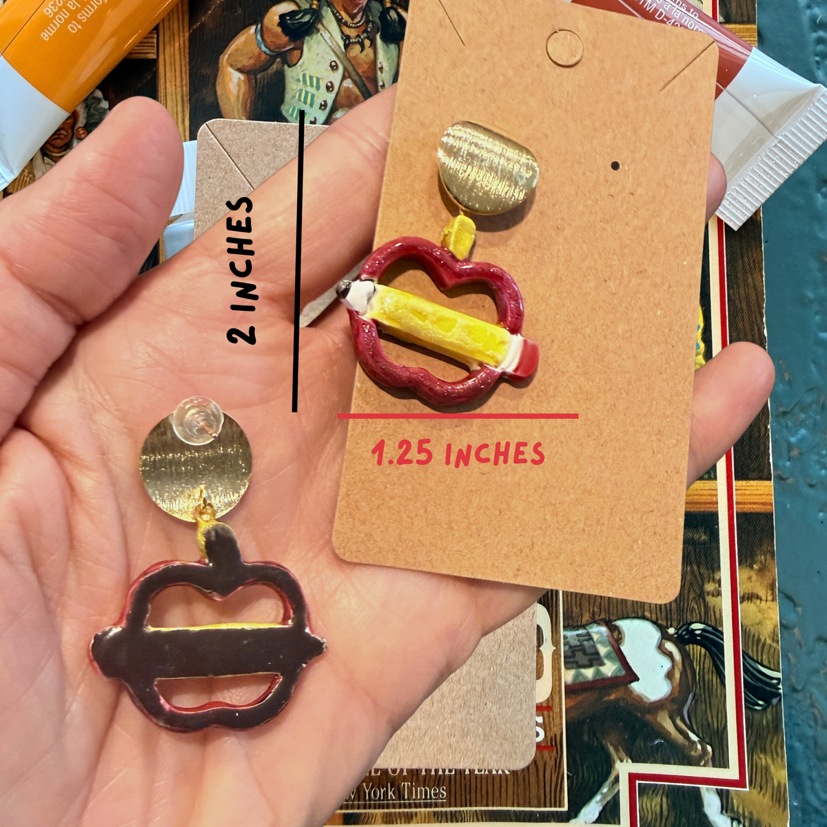 Front and back of an apple and pencil dangle earring, with dimensions marked 2 inches high by 1.25 inches wide.