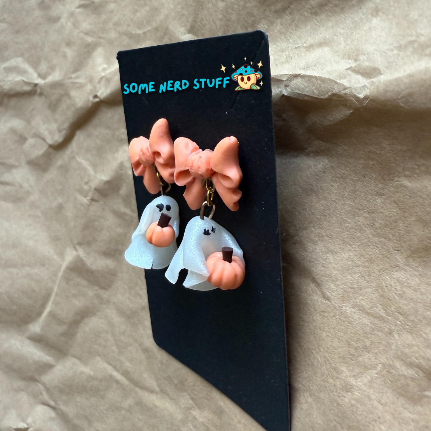 Polymer Clay Stud earrings with peach bows, phantoms holding pumpkins side view made by SomeNerdStuff