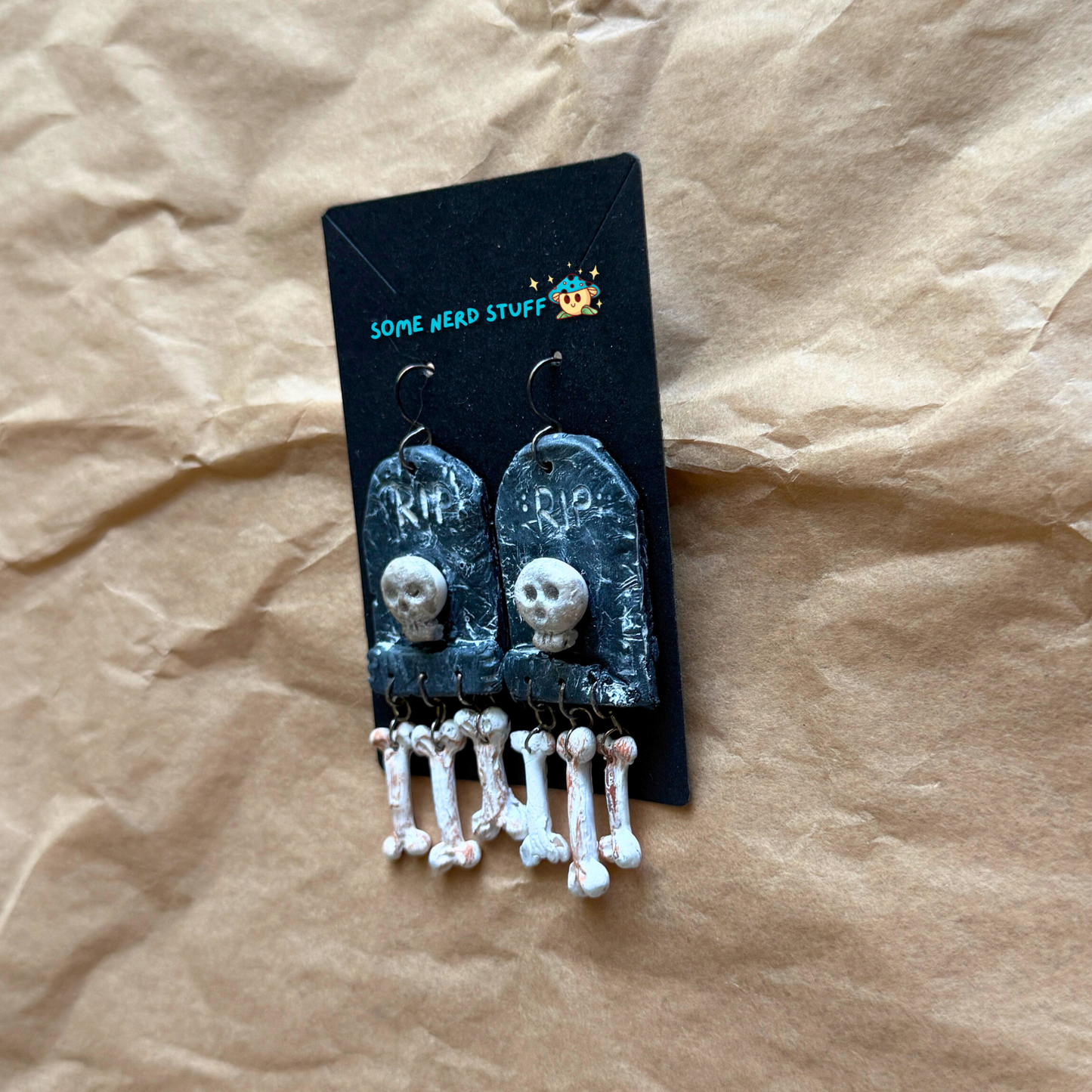 Phntom Parlor Polymer Clay tombstone skull and dangling bone earrings side view made by SomeNerdStuff