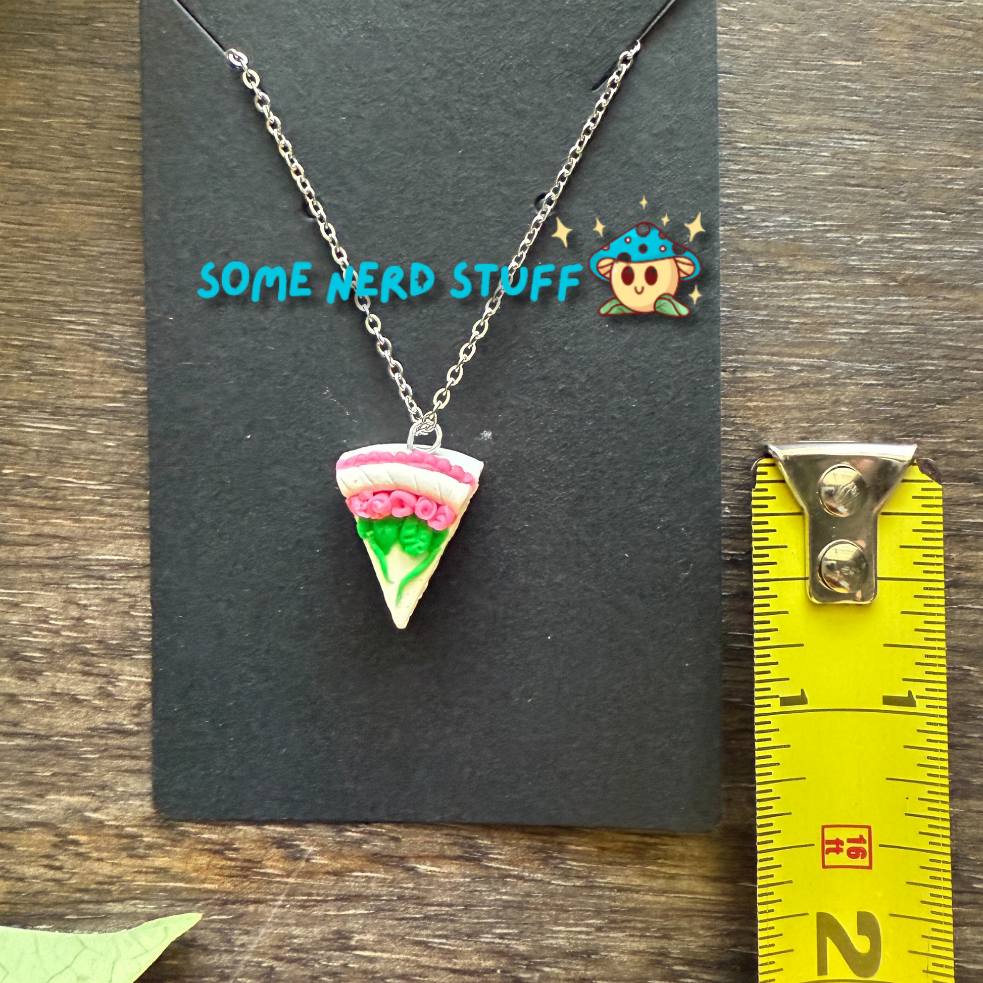 Pretty in Pink inspired Vanilla polymer clay charm and necklace with layers shown with measuring tape made by SomeNerdStuff