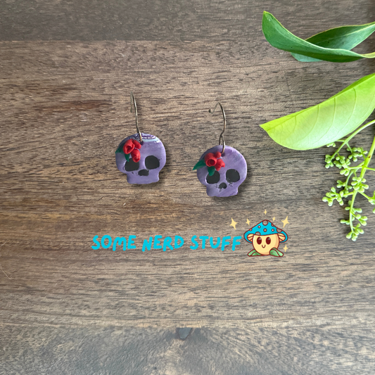 Purple Polymer Clay skulls decorated with red roses made by SomeNerdStuff