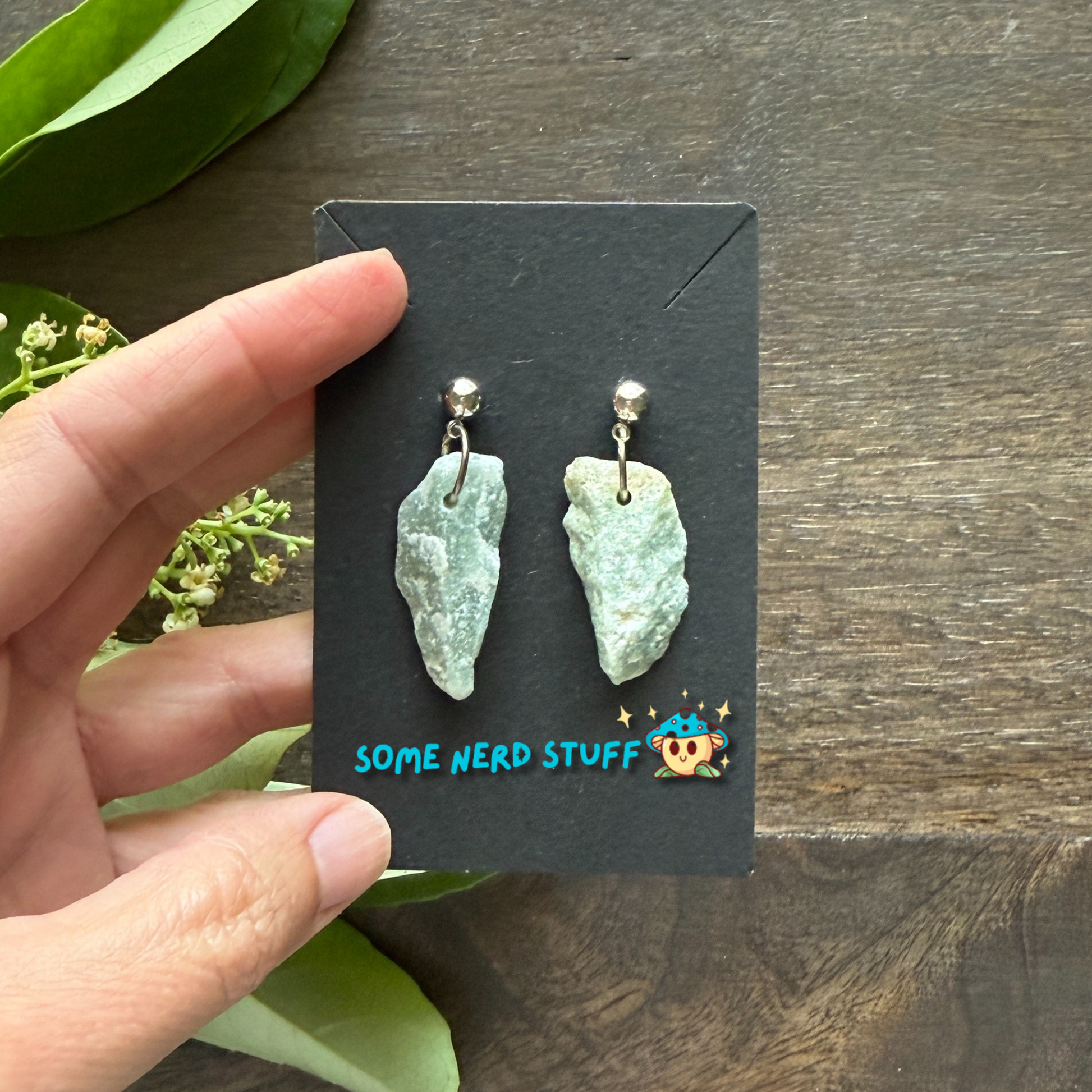 Rough Aquarmine Gemstone Dangling Earrings created by SomeNerdStuff hand holding earrings close up