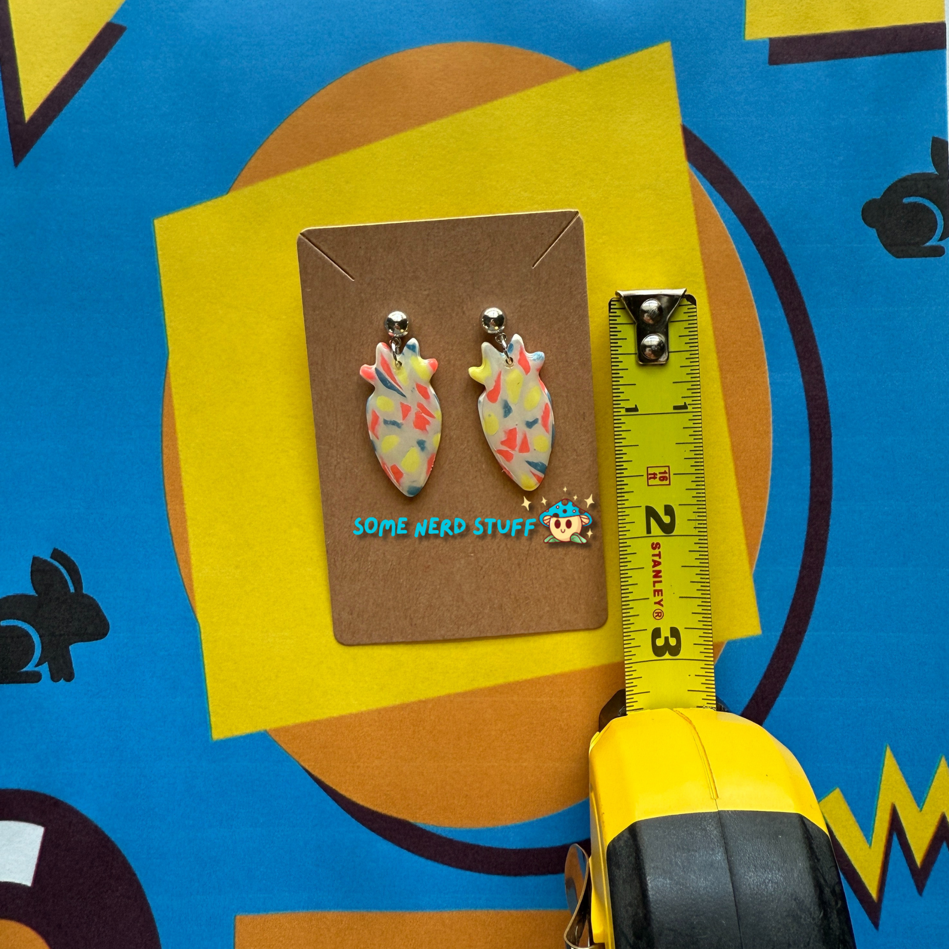 Carrot Silhouette Polymer Clay Earrings inspired by Saved by the Bell 90s show multicolor shown with measuring tape made by SomenerdStuff