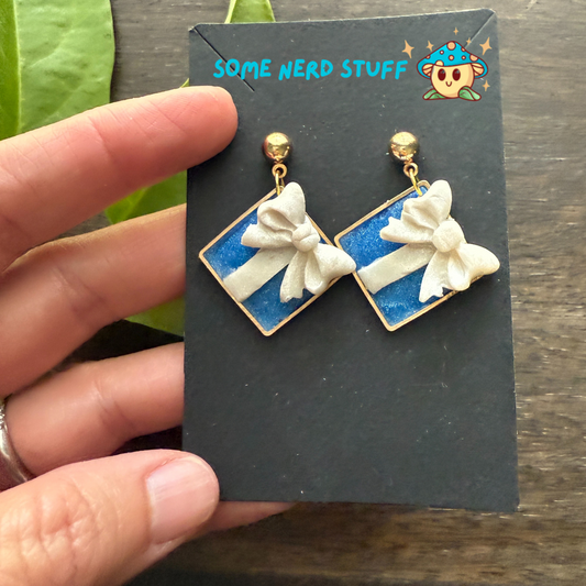 Tiffany's jewlery inspired polymer clay bow earrings, shown with hand for size.