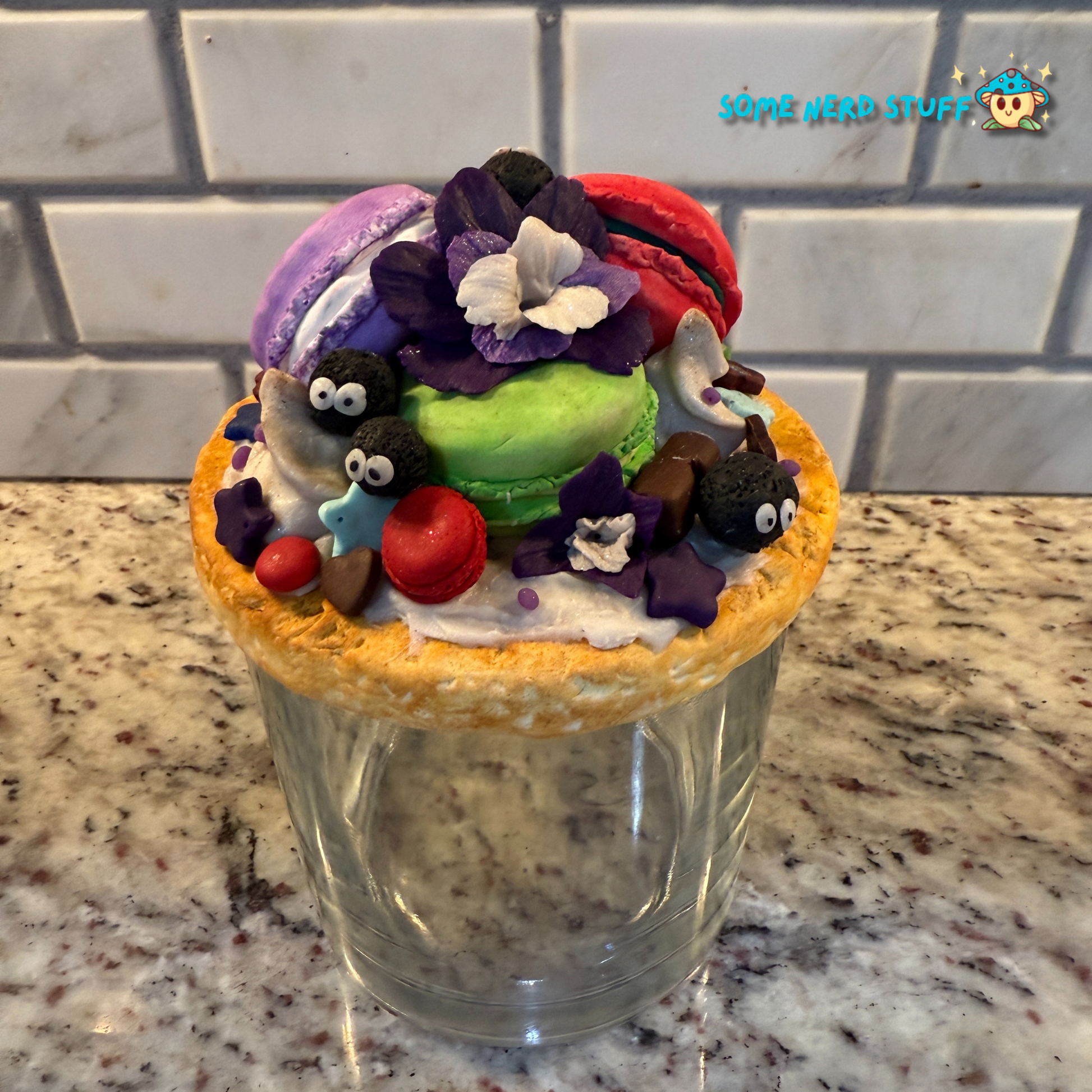 Soot Sprite Stash Jar topped with polymer clay macarooms, Soot Sprites, chocolate pieces, orchids.