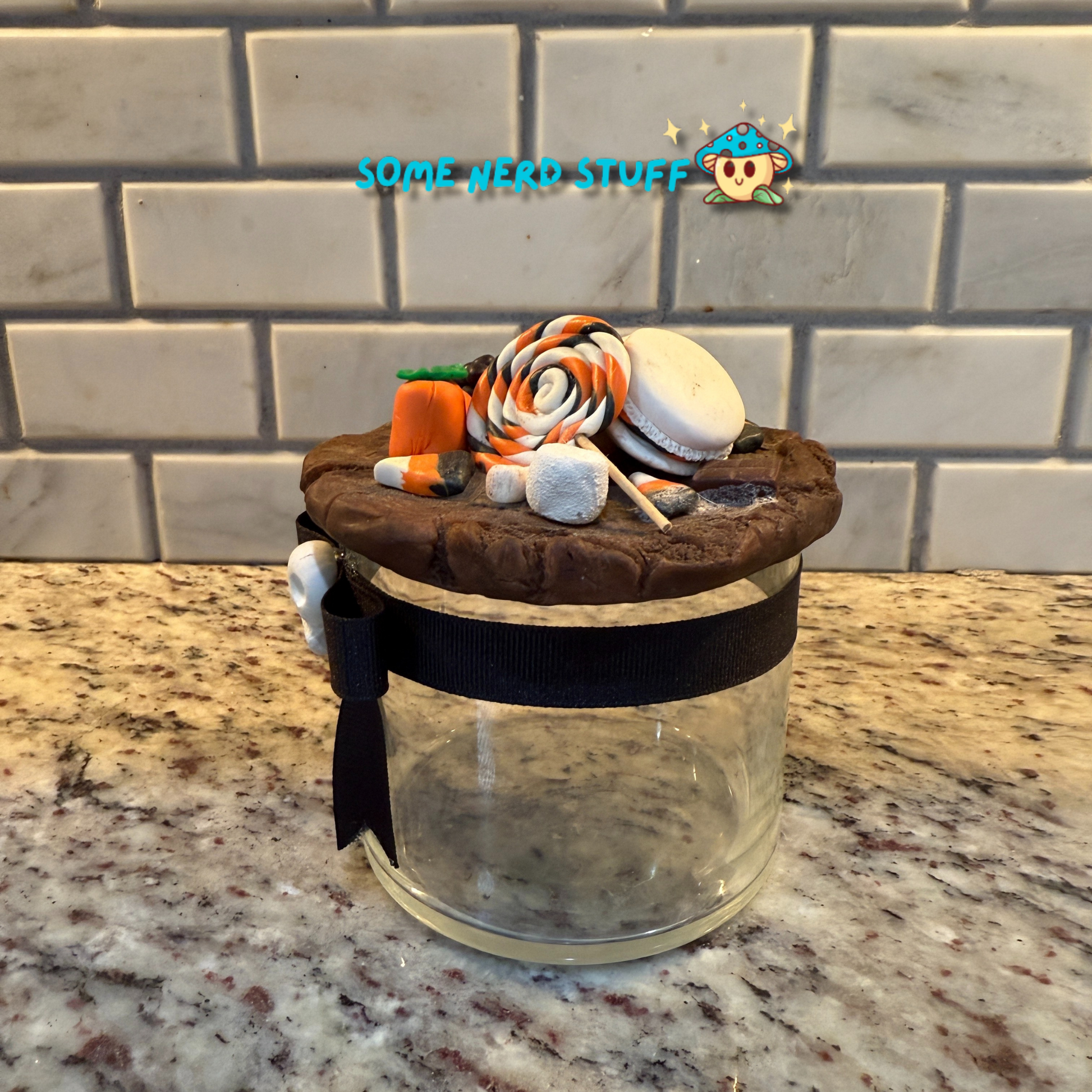 Spooktacular Stash Jar made with polymer clay including macarons, marshmellos, candy lollipop, candy corn, and candy corn pumpkin.