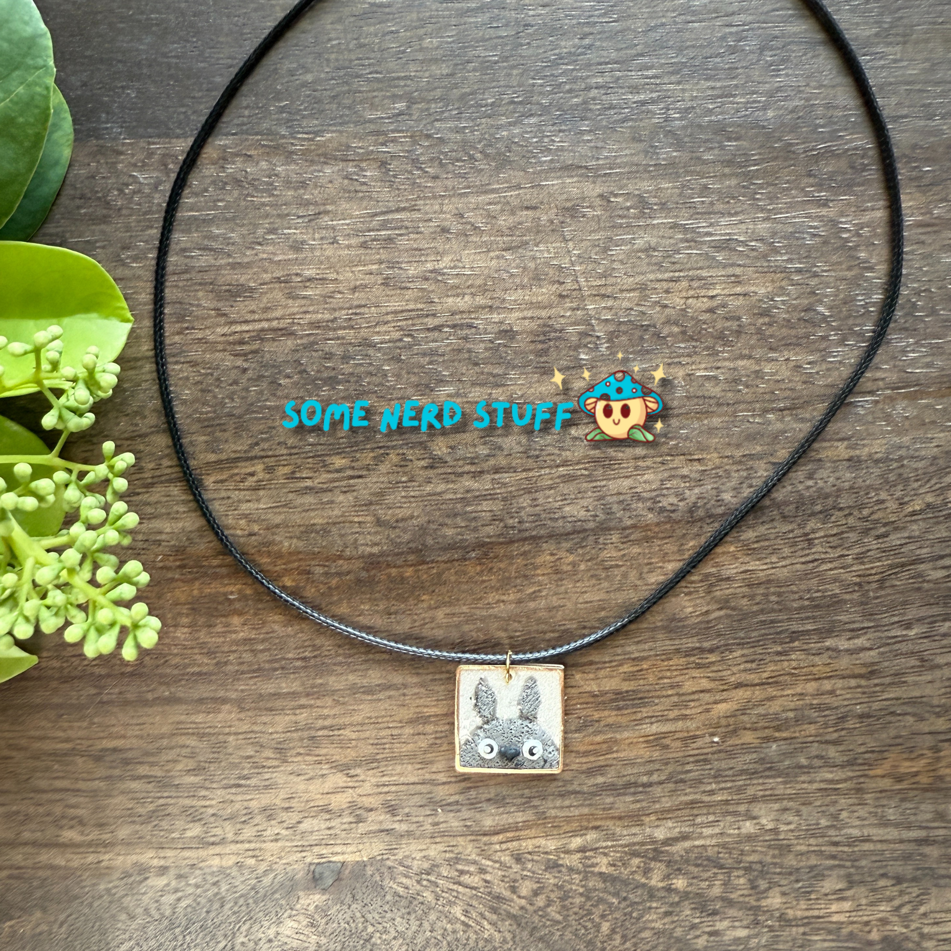 Polymer Clay Charm totoro in a metal square frame handing from a necklace with clasps made by SomeNerdStuff