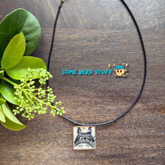 Acrylic hand painted Charm totoro in a metal square frame handing from a necklace with clasps made by SomeNerdStuff