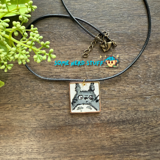 Acrylic hand painted Charm totoro in a metal square frame handing from a necklace with clasps made by SomeNerdStuff