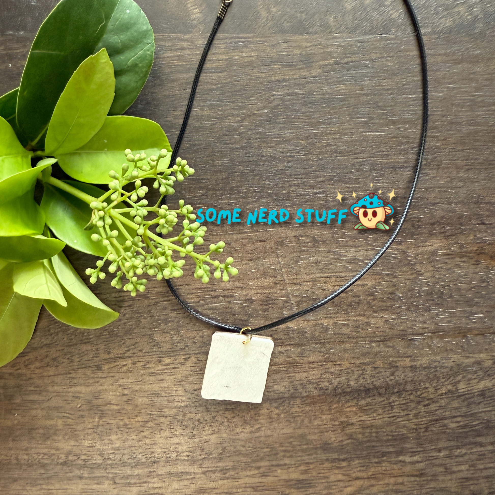 Acrylic hand painted Charm totoro in a metal square frame handing from a necklace with clasps made by SomeNerdStuff