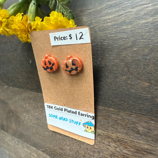 Halloween-themed pumpkin earrings on a cardboard backing with price and 18k plated earrings
